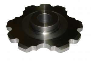 Metalowy element z ząbkami na obwodzie i centralnym otworem, obrobiony z widocznymi śladami obróbki skrawaniem, leżący na białym tle.