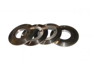 Cztery identyczne, metalowe pierścienie z centralnym otworem i trzema mniejszymi otworami obwodowymi, ułożone ukośnie na białym tle, widoczne ślady obróbki.