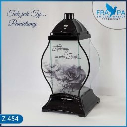 FRAPA Producent Zniczy i Wkładów | Dekoracje wnętrz | Boże Narodzenie | Wielkanoc - Czarny, elegancki znicz szklany z motywem czarnej róży i napisem 'Tęsknimy za Tobą, Babciu', stojący na białym tle z niebieską obwódką, widoczne logo producenta FRA-PA oraz oznaczenie modelu Z-454.