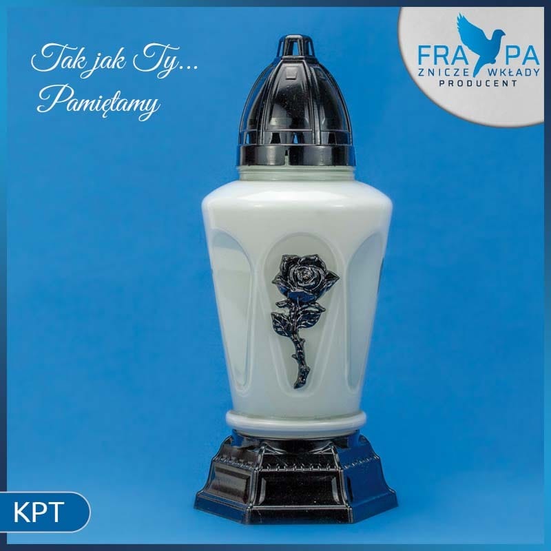 Szklany znicz w kolorze białym z czarną plastikową nakładką i podstawą, ozdobiony wytłoczonym motywem róży, na niebieskim tle.