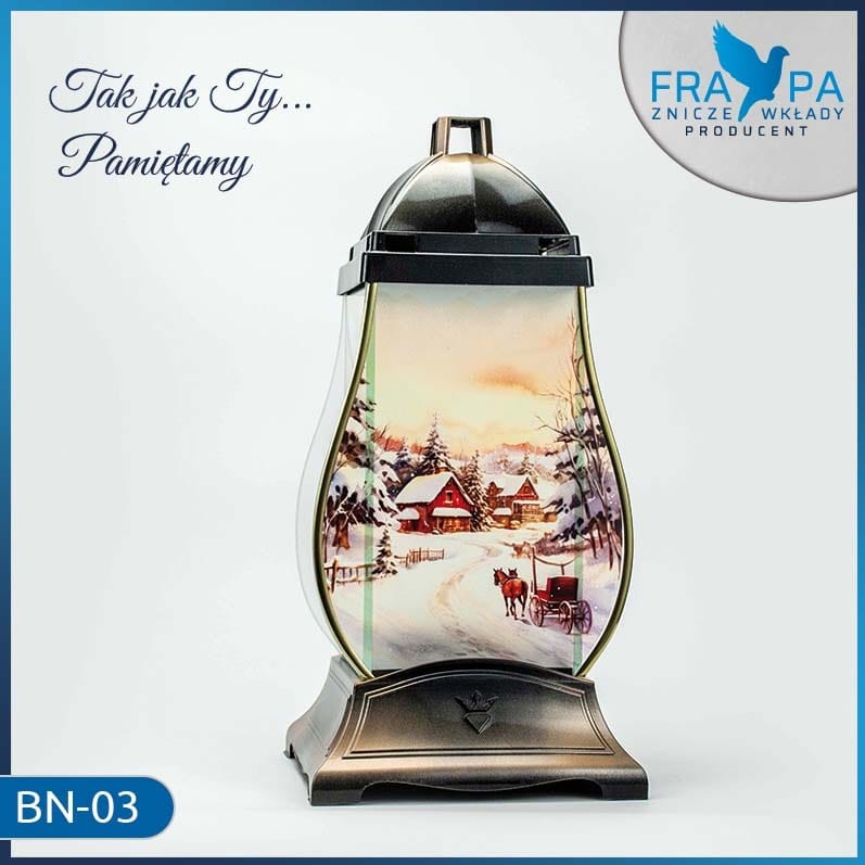 Lampion nagrobny z motywem zimowego krajobrazu z saniami, na podstawie z brązowego metalu, z napisem 'Tak jak Ty... Pamiętamy' i logo producenta w tle.