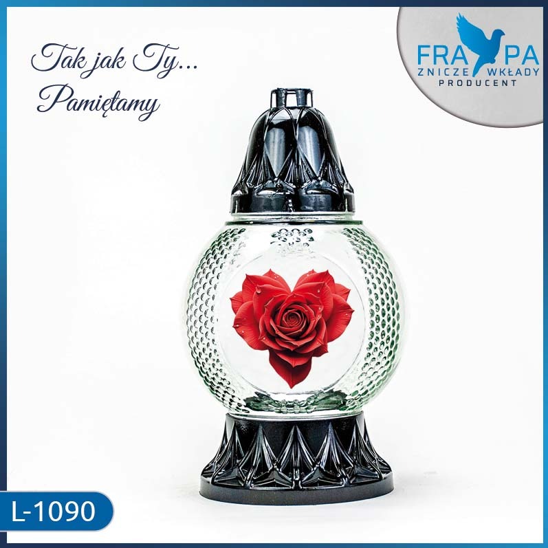 Szklany znicz L-1090 z czerwoną różą w kształcie serca, czarną nakładką i podstawą. Widoczne logo producenta. Idealny do upamiętnienia bliskich.