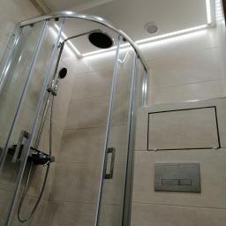 Dawid K - Kabina prysznicowa półokrągła z chromowanymi profilami, deszczownicą i baterią termostatyczną, oświetlenie LED podsufitowe, płytki ceramiczne w beżowym odcieniu, przycisk spłuczki podtynkowy.