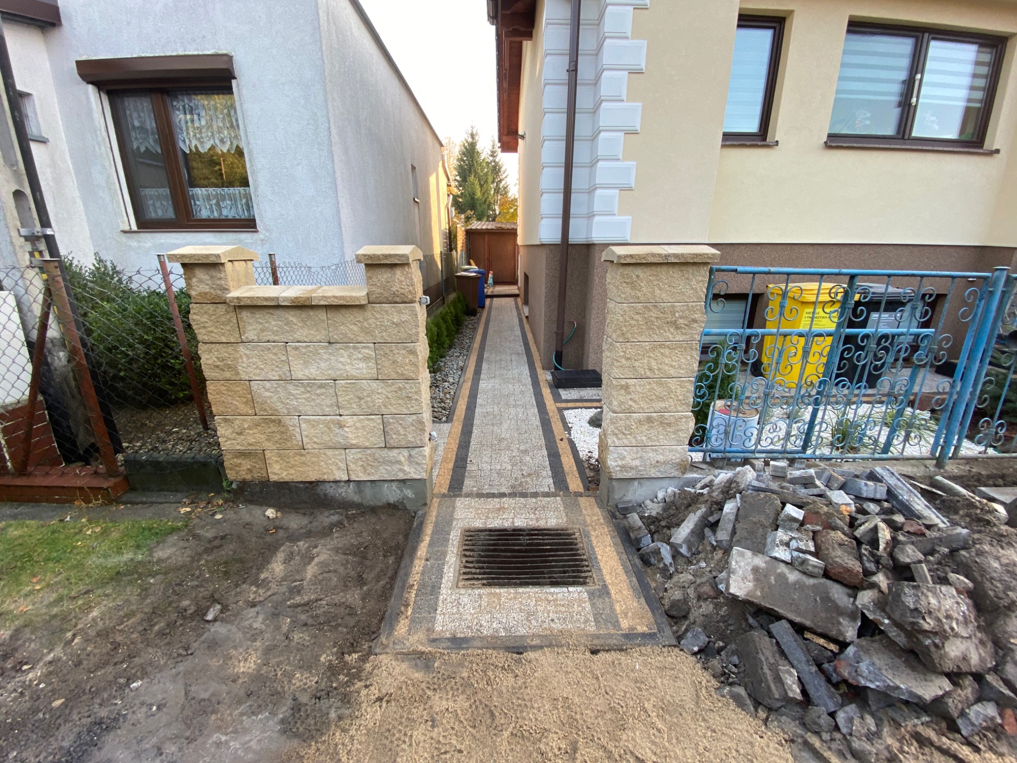 Układanie opaski wokół domu z kostki brukowej, wraz z wykonaniem paru stopni oraz murowanie ogrodzenia.