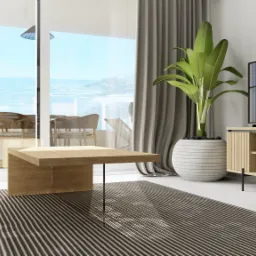 Jasne wnętrze salonu z widokiem na morze, drewniany stolik kawowy, szafka RTV z rośliną w donicy, szaro-biały dywan w paski, szara sofa częściowo widoczna po lewej stronie.