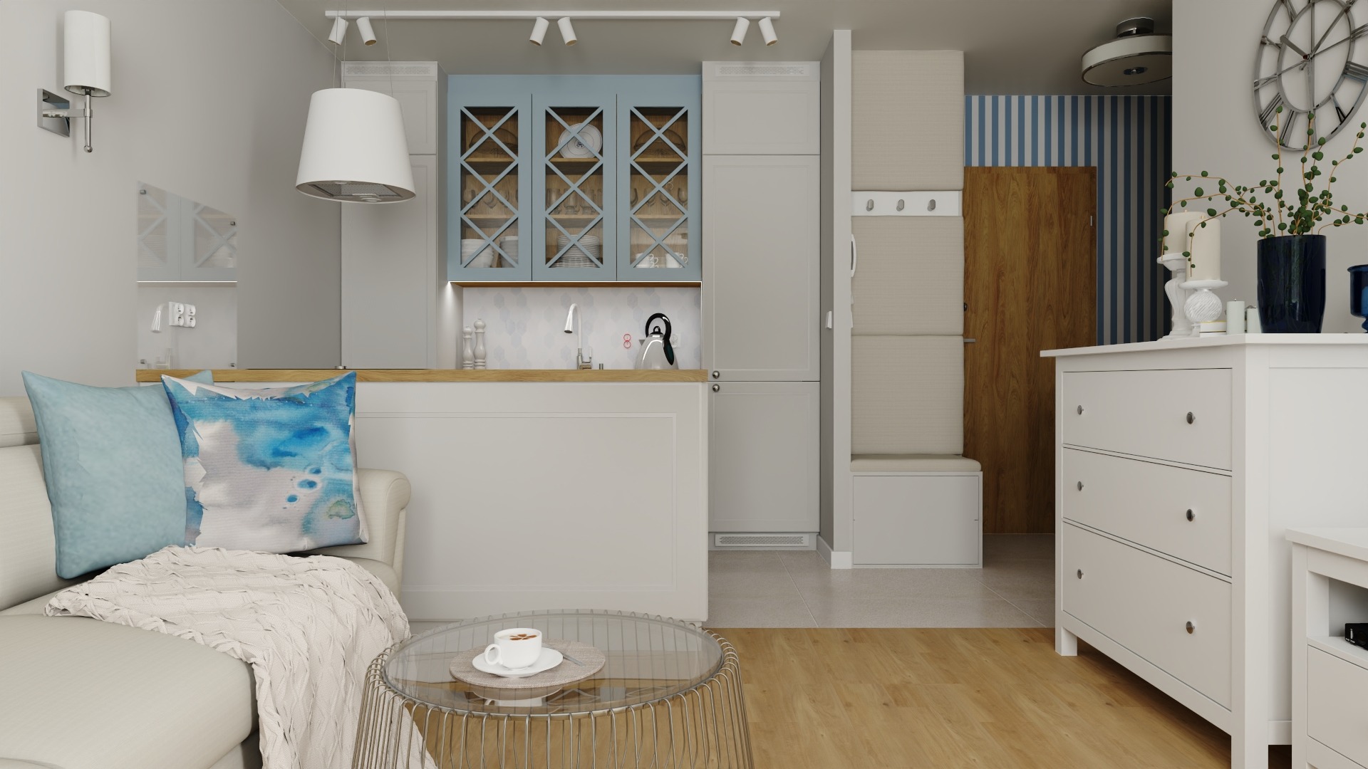 Wnętrze mieszkania z aneksem kuchennym w stylu skandynawskim, z niebieskimi akcentami, widok na przeszklone szafki kuchenne i dekoracyjne poduszki na sofie.