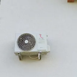 Zewnętrzna jednostka klimatyzacji Rotenso Imoto 5kW zamontowana na jasnej elewacji budynku, widoczne mocowania i fragment okna.