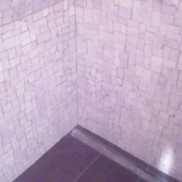 Wykończona kabina prysznicowa z mozaiką na ścianach i ciemnymi płytkami podłogowymi. Widoczny odpływ liniowy. Nietypowe połączenie kolorów i małych kwadratowych płytek.