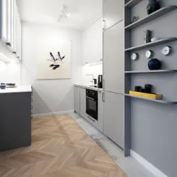 Nowoczesna kuchnia w odcieniach szarości i bieli z parkietem ułożonym w jodełkę, oświetleniem punktowym i dekoracyjnym obrazem z motywem ptaków na ścianie.