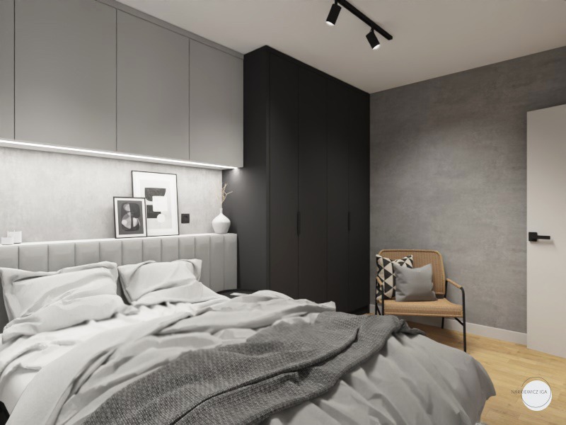 Nowoczesna sypialnia w szarościach z łóżkiem z tapicerowanym wezgłowiem, czarną szafą i rattanowym fotelem z geometryczną poduszką.