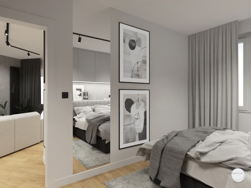 Nowoczesna sypialnia z łóżkiem, szarą narzutą i abstrakcyjnymi obrazami w czarnych ramach, widoczna również część salonu z białą sofą, oświetlenie szynowe.
