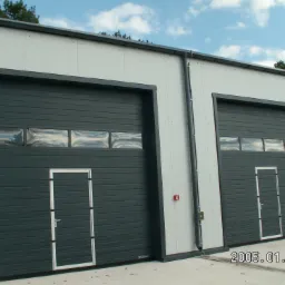 Dwie szare bramy przemysłowe z oknami i drzwiami wejściowymi, zamontowane w hali o białej elewacji, z widocznym logo WIŚNIOWSKI w dolnym rogu jednej z bram.