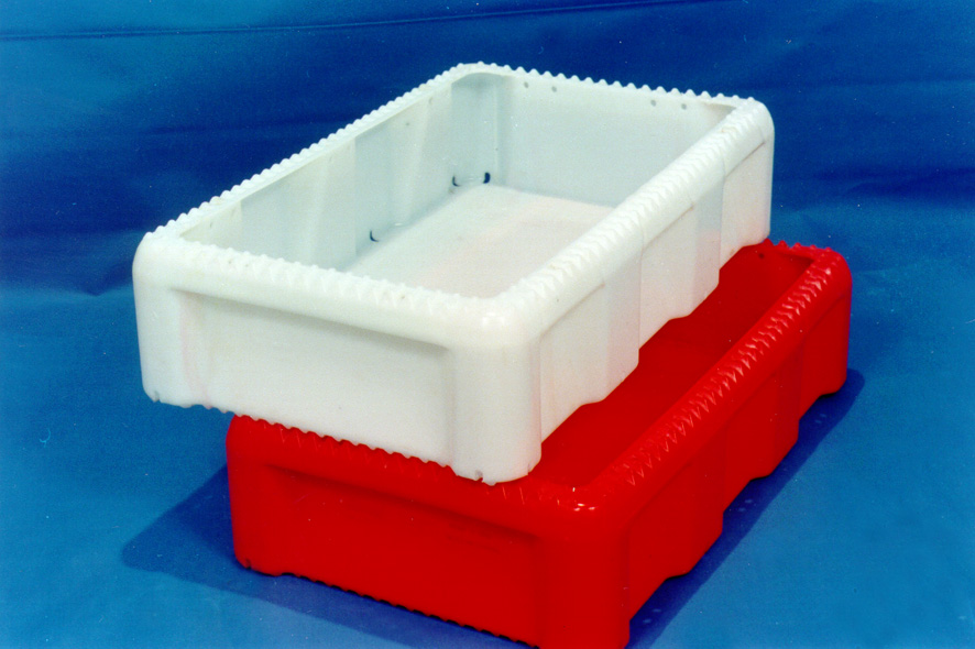 Dwie plastikowe skrzynki: biała na czerwonej, z karbowanymi krawędziami na niebieskim tle.