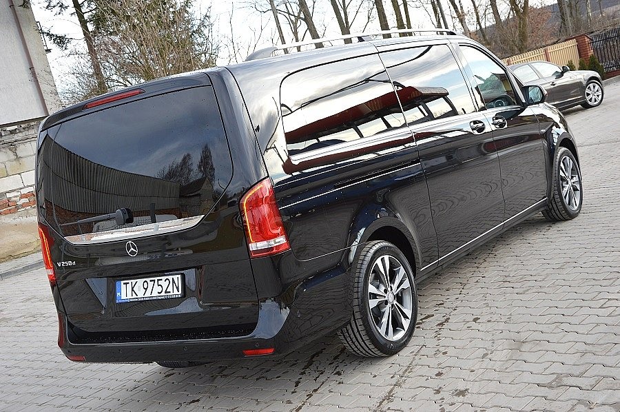 Czarny Mercedes V250d z relingami dachowymi, widok z tyłu, zaparkowany na kostce brukowej, z widoczną tablicą rejestracyjną TK 9752N.