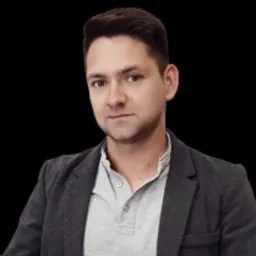 Portret mężczyzny w szarej marynarce i jasnej koszulce polo na czarnym tle.