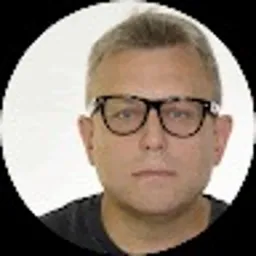 Portret mężczyzny w okularach z czarnymi oprawkami na białym tle, prawdopodobnie zdjęcie profilowe.