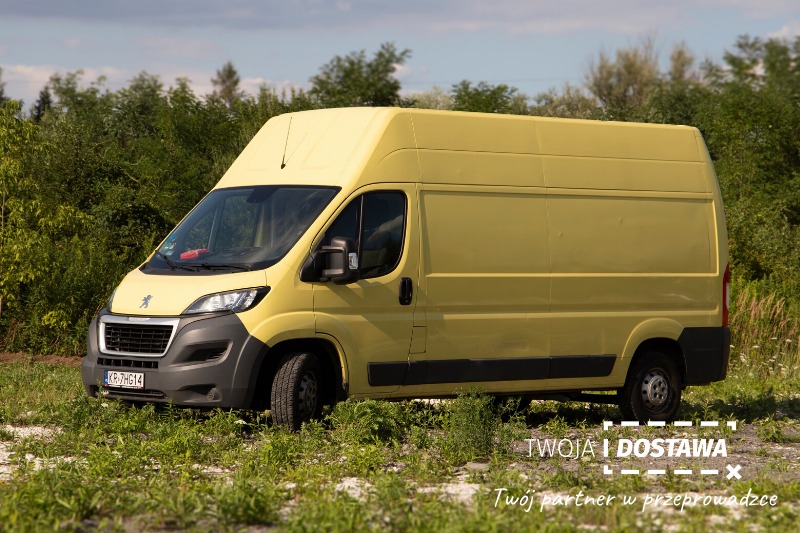 Żółty bus dostawczy Peugeot z logo firmy 'Twoja i Dostawa' na tle zieleni, zaparkowany na trawie.