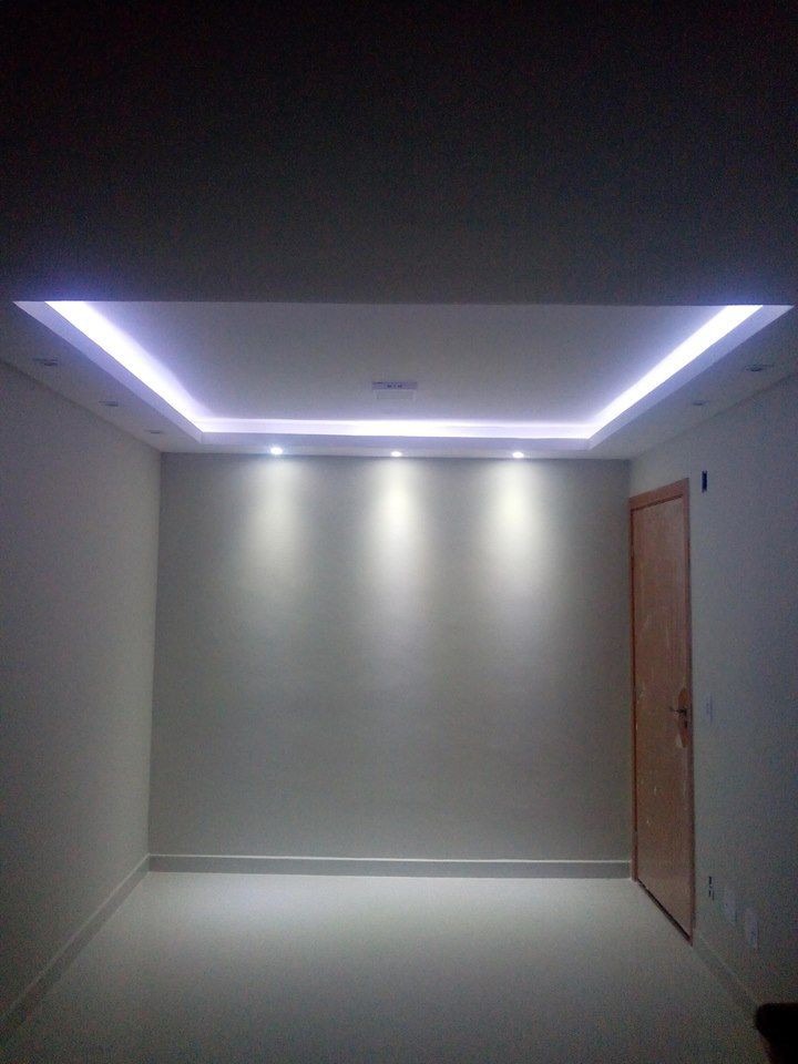 Wnętrze pokoju po remoncie w Częstochowie, ściany pokryte gładzią w odcieniach szarości, sufit z podwieszanym oświetleniem LED, widoczna drewniana ościeżnica drzwiowa.