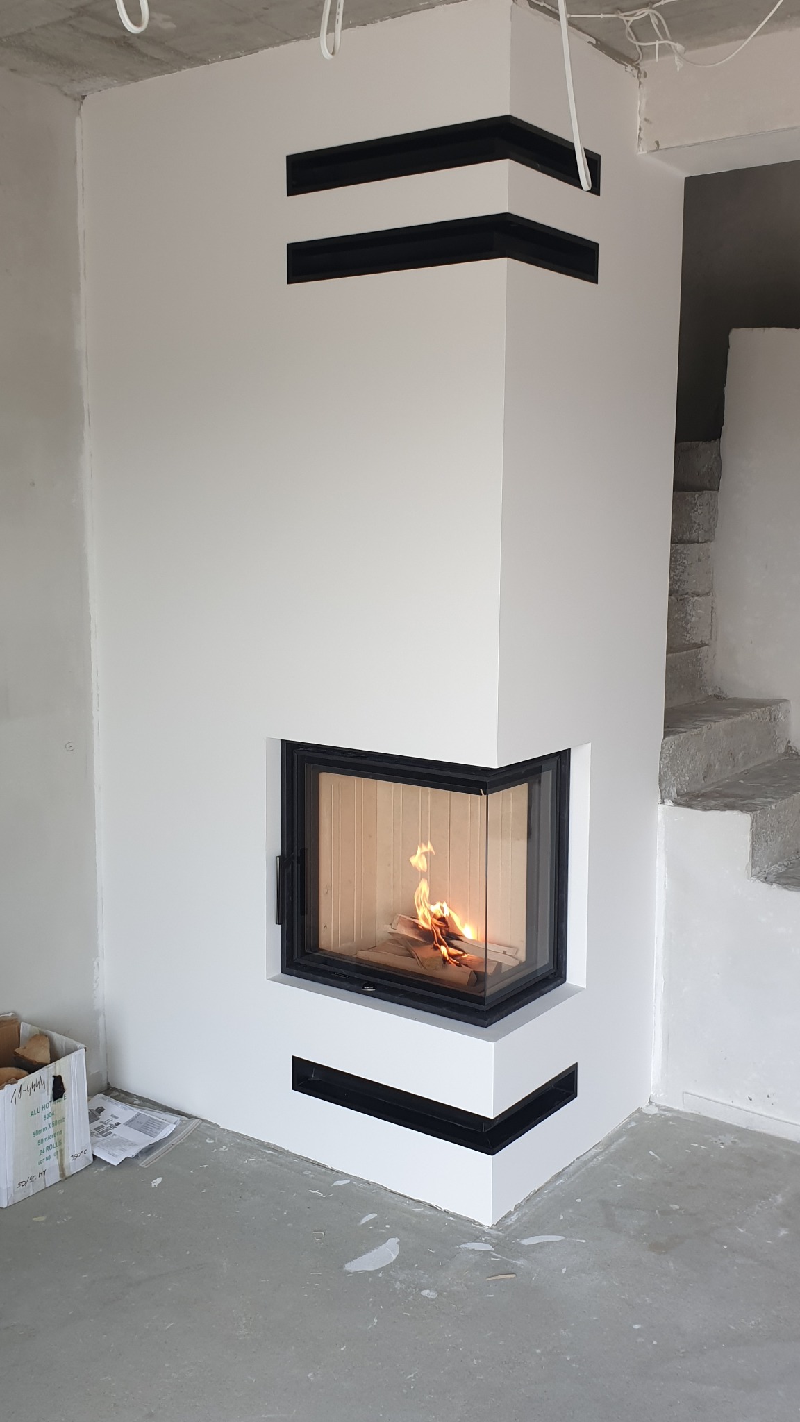 Nowoczesny kominek z łamaną szybą otwieraną do góry