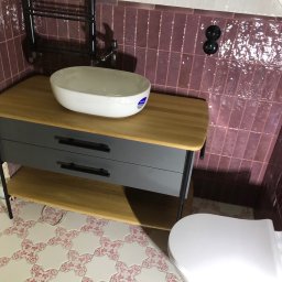 Renovation Hause Wojciech Tworkowski - Nowoczesna łazienka z umywalką nablatową na szafce z szufladami, fioletowe płytki na ścianie, ozdobne płytki podłogowe w gwiazdy z różowym wzorem i grzejnik drabinkowy.