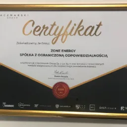Oprawiony w złotą ramkę certyfikat firmy Kaczmarski Group dla ZONE ENERGY Spółka z ograniczoną odpowiedzialnością, potwierdzający współpracę i korzystanie z nowoczesnych narzędzi biznesowych,...