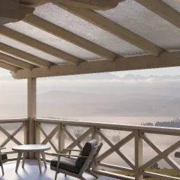 Zadaszony drewniany balkon z widokiem na góry spowite mgłą, wyposażony w dwa krzesła i okrągły stolik.