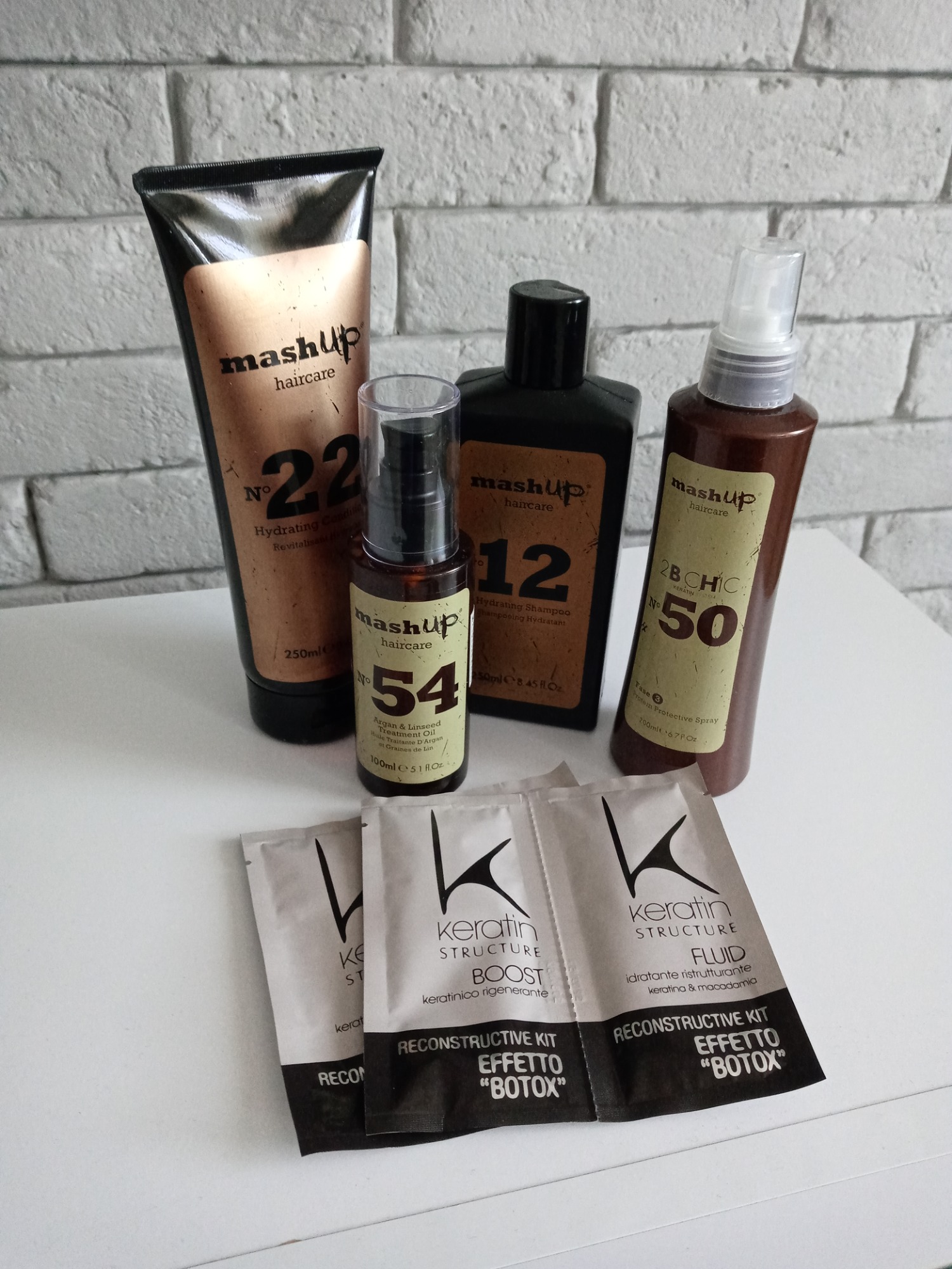 Zestaw kosmetyków do pielęgnacji włosów marki Mashup i Keratin Structure, zawierający odżywkę, szampon, olejek, spray ochronny i saszetki z fluidem do rekonstrukcji włosów.