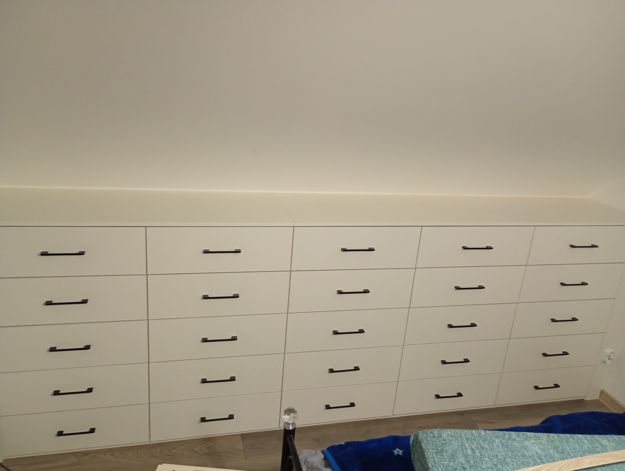 Zabudowa szufladowa w skosie i szafa.