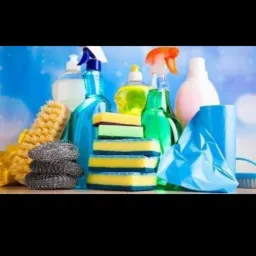 Zestaw środków czystości i akcesoriów, w tym butelki z płynami, gąbki i szczotki, gotowy do użycia przez firmę sprzątającą w Pruszkowie.