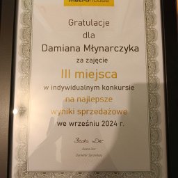 Damian Mlynarczyk - Dyplom w czarnej ramce z gratulacjami dla Damiana Młynarczyka za zajęcie III miejsca w indywidualnym konkursie na najlepsze wyniki sprzedażowe we wrześniu 2024 r., podpisany przez Beatę Dec...