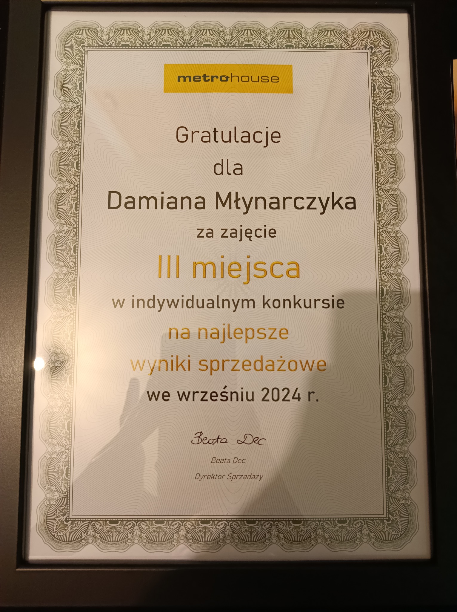 Dyplom w czarnej ramce z gratulacjami dla Damiana Młynarczyka za zajęcie III miejsca w indywidualnym konkursie na najlepsze wyniki sprzedażowe we wrześniu 2024 r., podpisany przez Beatę Dec...