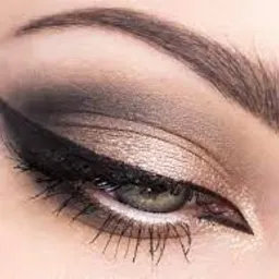 Detal oka z precyzyjną czarną kreską eyelinerem i cieniowaniem w odcieniach brązu i złota, podkreślającym naturalny kolor tęczówki.