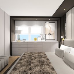 IMPRESA INTERIOR Andrzej Jerominek - Nowoczesna sypialnia z szarą komodą pod oknem, dekoracjami, abstrakcyjnym obrazem i łóżkiem z futrzanym pledem.