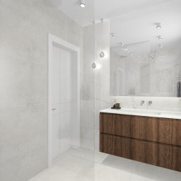 IMPRESA INTERIOR Andrzej Jerominek - Wizualizacja łazienki z drewnianą szafką pod umywalką, marmurowymi ścianami i podświetlanym lustrem, akcentowana przez wiszące lampy kuliste.