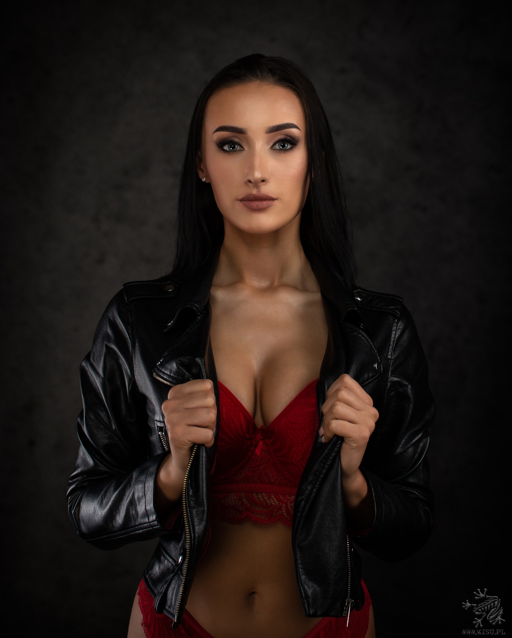 Portret kobiety w czerwonej bieliźnie i czarnej skórzanej kurtce, wykonany w Katowicach na ciemnym tle.