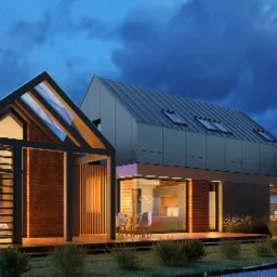 Nowoczesny dom jednorodzinny z ceglaną elewacją, dużymi przeszkleniami i metalowym dachem w odcieniach szarości, oświetlony wieczornym światłem, z widocznym wnętrzem i tarasem.