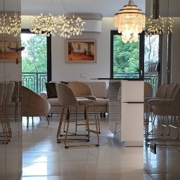 Widok na salon z korytarza. Korytarz jest w całości obudowany płytami akrylowymi. Również drzwi od strony korytarza zostały wykończone tym materiałem.