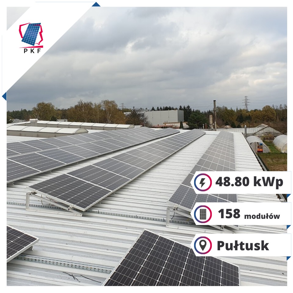 Widok z góry na instalację paneli słonecznych na dachu budynku przemysłowego w pochmurny dzień, z logo firmy PKF w lewym górnym rogu i informacją o mocy instalacji 48.80 kWp, 158 modułów...