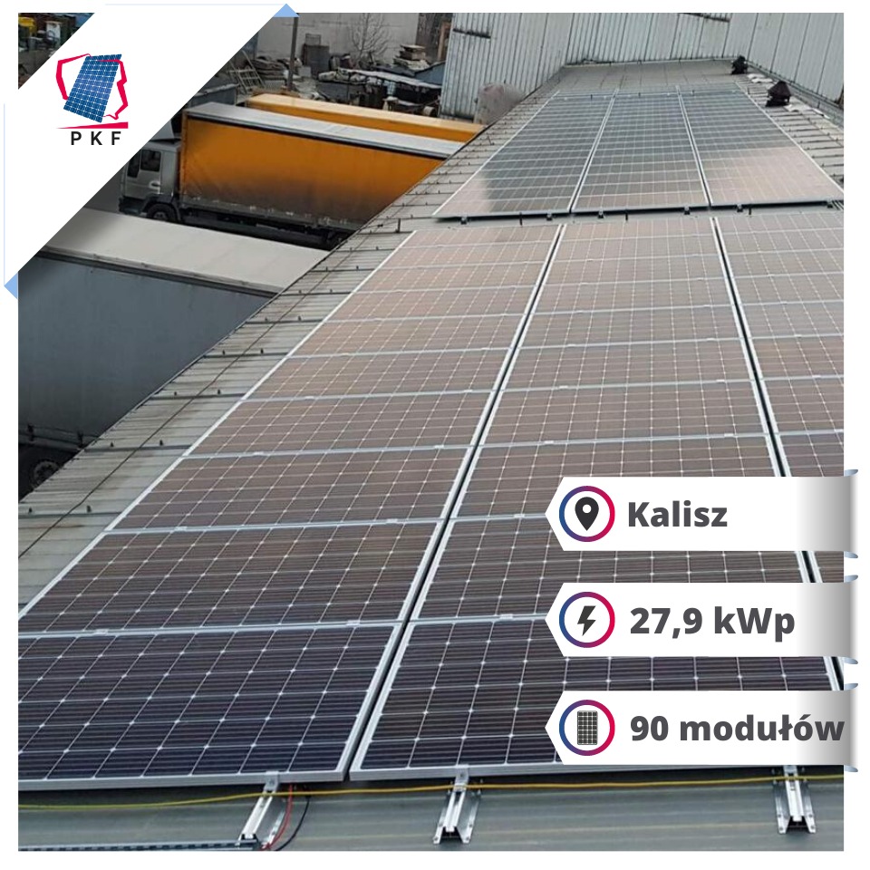 Instalacja paneli słonecznych na dachu budynku przemysłowego, widoczne 90 modułów o mocy 27,9 kWp, w tle zaparkowane samochody ciężarowe.