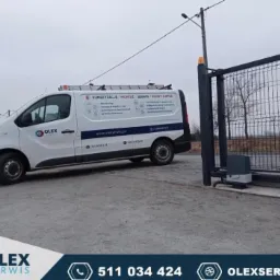 Biały samochód serwisowy firmy Olex Serwis z drabiną na dachu, zaparkowany obok automatycznej bramy wjazdowej z napędem elektrycznym.