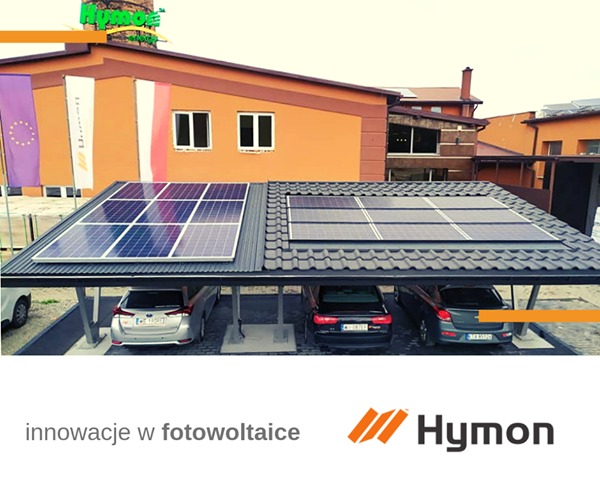 Zadaszenie parkingowe z panelami fotowoltaicznymi, trzy zaparkowane samochody, budynek w tle z flagami, logo firmy w dolnej części.