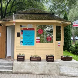 Żółty pawilon z napisem 'Nasza Oferta' prezentujący ubezpieczenia komunikacyjne, na życie, mieszkaniowe, zdrowotne i dla firm, z logo DPD Pickup w oknach.