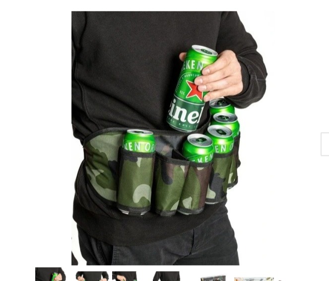 Mężczyzna w czarnej bluzie trzyma puszkę piwa Heineken nad pasem biodrowym w kamuflażu z kilkoma puszkami piwa w środku.