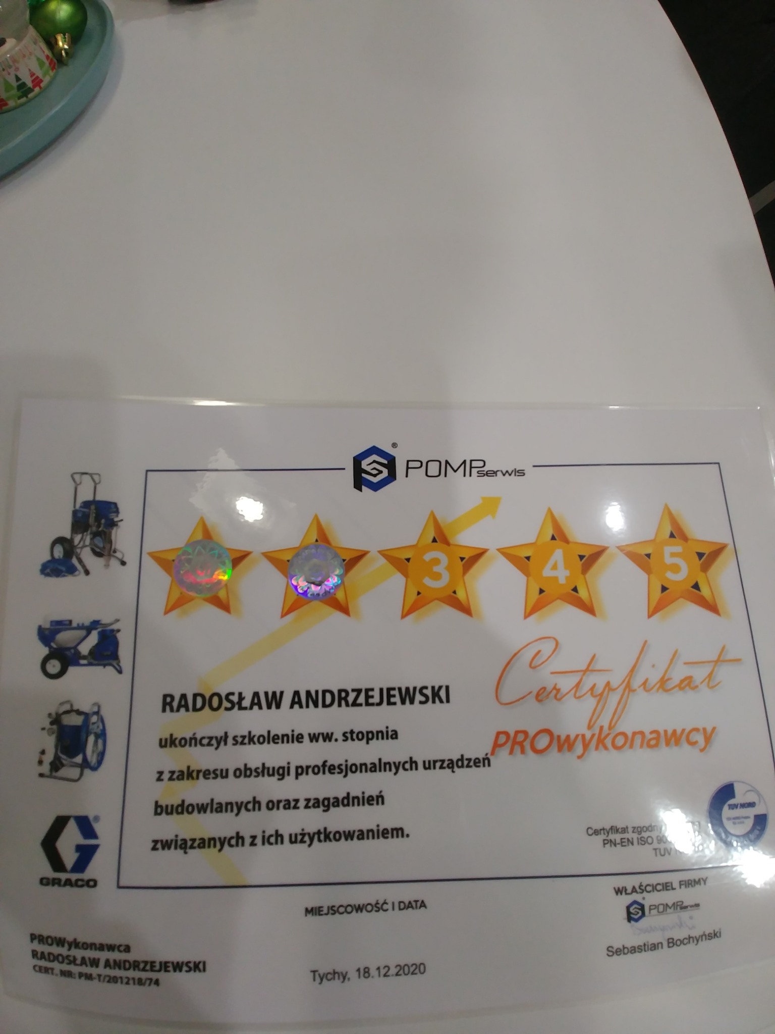 Certyfikat PROwykonawcy Radosława Andrzejewskiego z POMPserwis, potwierdzający ukończenie szkolenia z zakresu obsługi profesjonalnych urządzeń budowlanych, z logo Graco i oceną 5 gwiazdek.