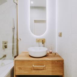 Kobieca łazienka ze złotymi akcentami.