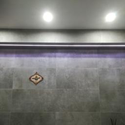 Instal-Expres - Szara łazienka z podświetlaną wnęką i dekoracyjną ozdobą na ścianie, oświetlenie sufitowe punktowe