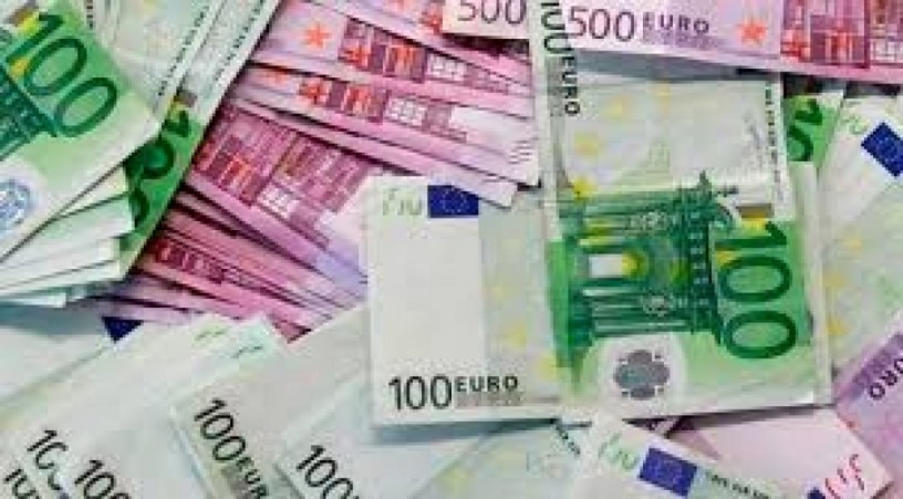 Stos banknotów euro o nominałach 100 i 500, ułożonych chaotycznie na płaskiej powierzchni, z przewagą zielonych i różowych barw.