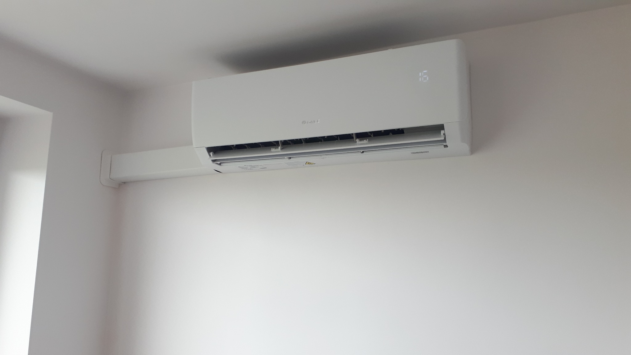 Zamontowana jednostka wewnętrzna klimatyzacji GREE Pular 3.5kW z wyświetlaną temperaturą 16 stopni Celsjusza na białej ścianie.