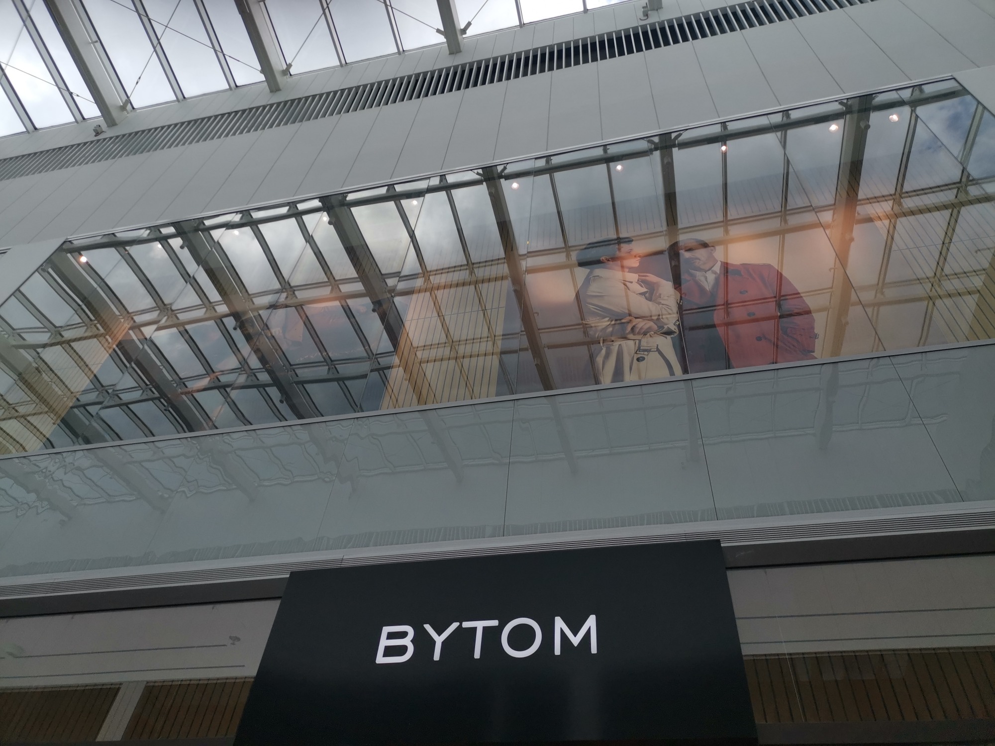 Szklana fasada budynku z widoczną reklamą marki Bytom i konstrukcją dachu