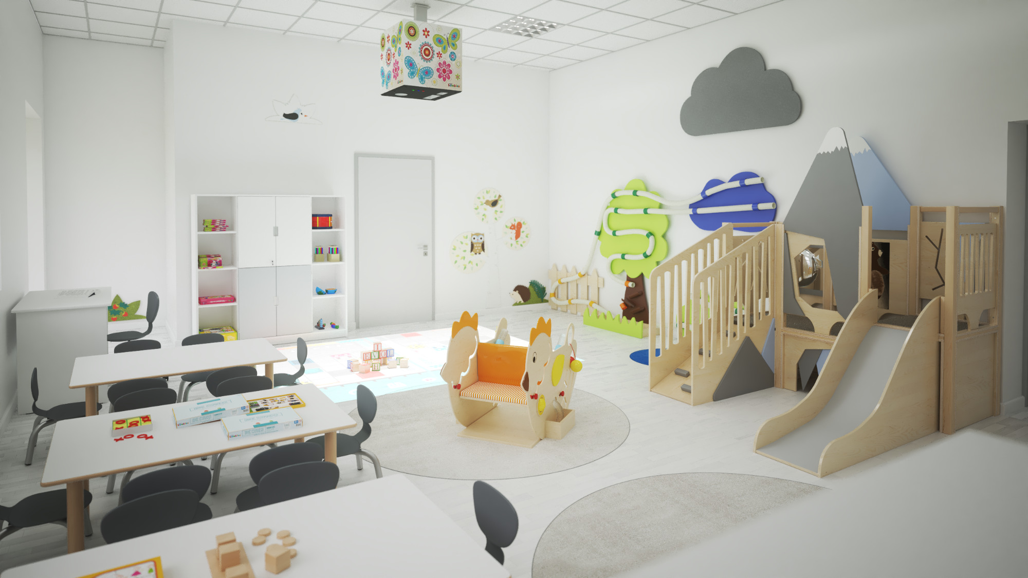 Jasne, przestronne wnętrze sali zabaw z drewnianymi meblami, stolikami z krzesłami, regałem z zabawkami, konstrukcją ze zjeżdżalnią i dekoracjami ściennymi w kształcie chmury, drzew i zwierząt.